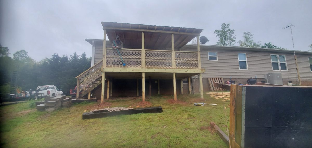 Elevated wooden deck under construction in a suburban backyard
